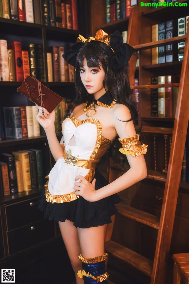 A woman dressed in a maid outfit holding a book.