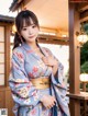 A woman in a blue kimono posing for a picture.