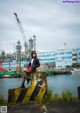 A woman sitting on top of a yellow and black pole.